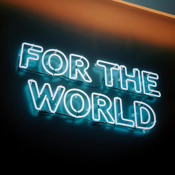 Image by Jon Tyson. Neon signage that reads "FOR THE WORLD"